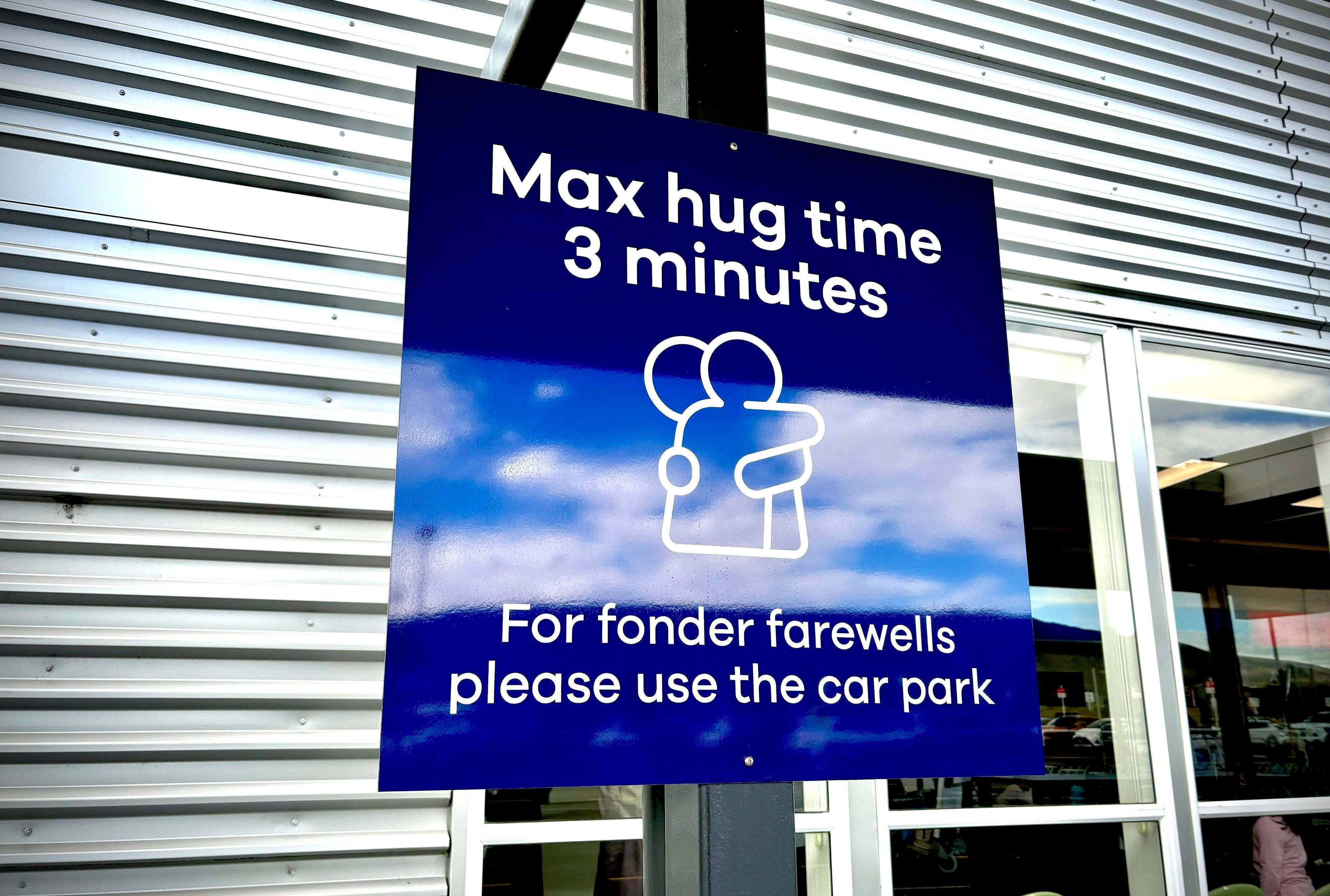 Das vom Flughafen Dunedin zur Verfügung gestellte Foto zeigt ein Schild, das über die zeitlichen Beschränkungen für Besucher des Passagierabfertigungsbereichs vor dem Flughafen informiert.