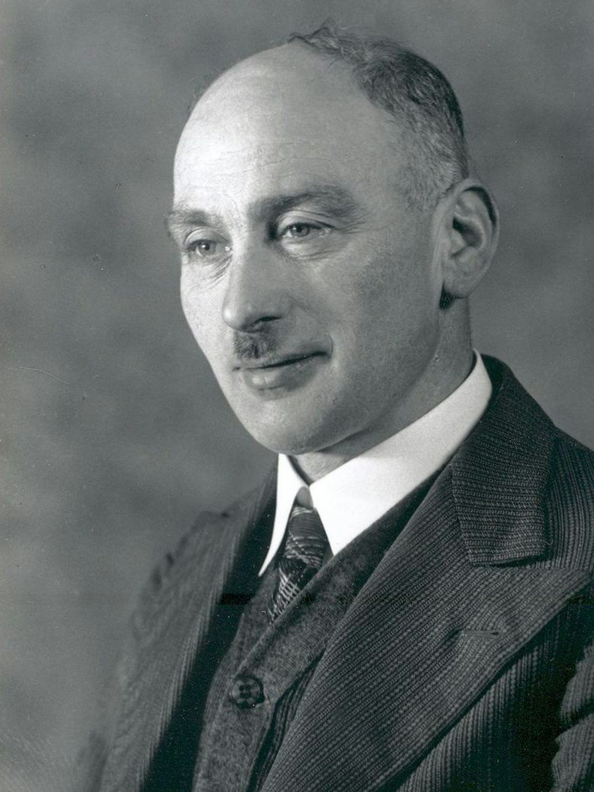 Schwarz-Weiß-Porträt eines Mannes im Anzug.