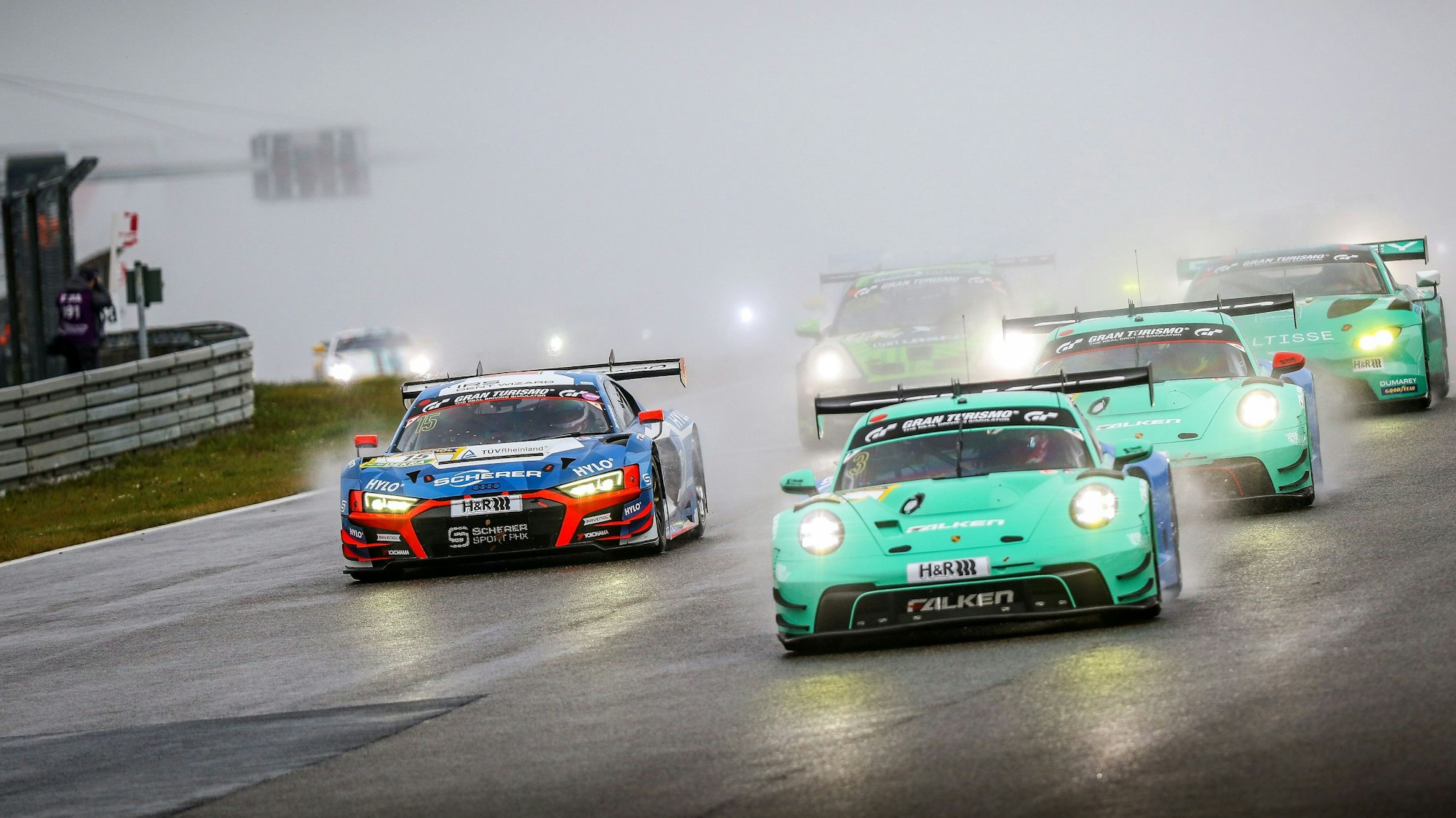 Rennautos fahren nah beieinander, im Hintergrund ist wegen der Gischt kaum etwas zu erkennen.