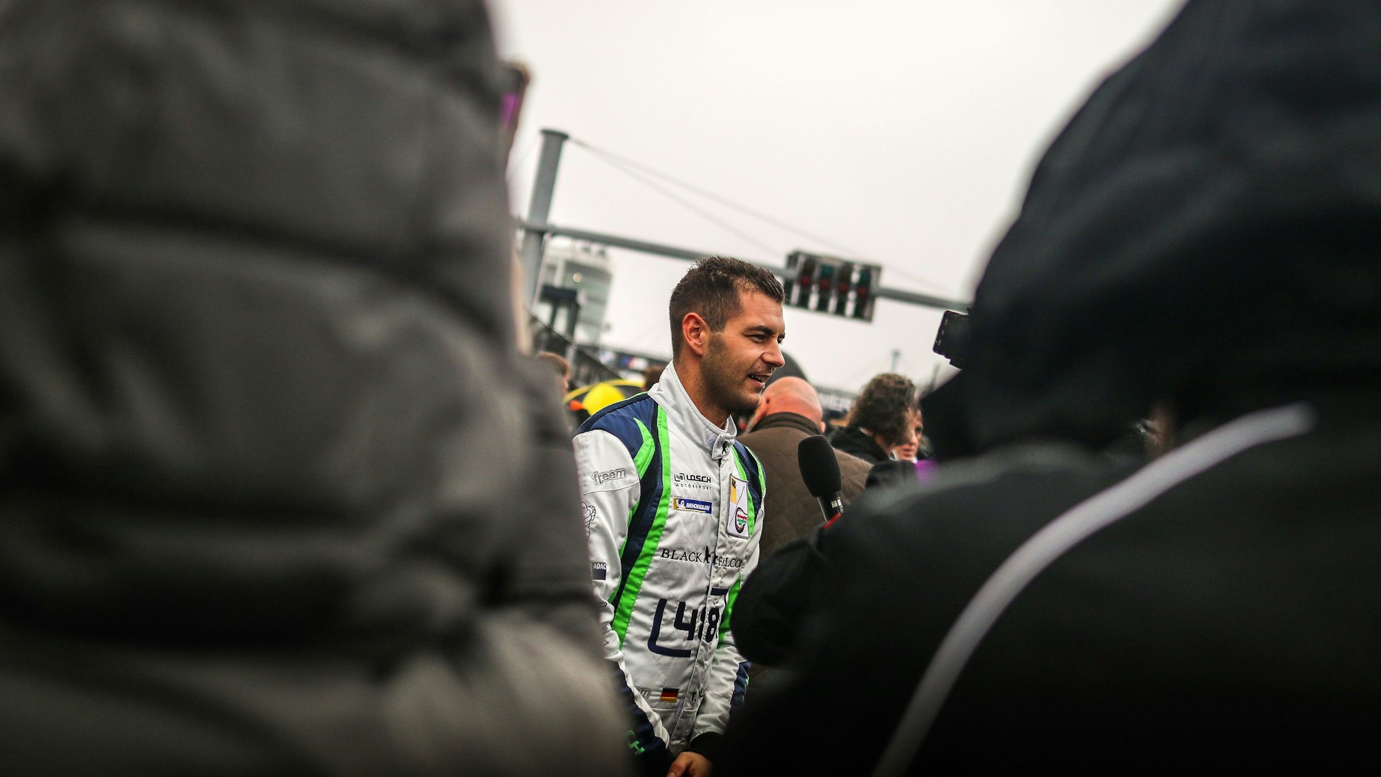 Tobias Müller wird interviewt. Zuschauer in der Boxengasse hören zu.