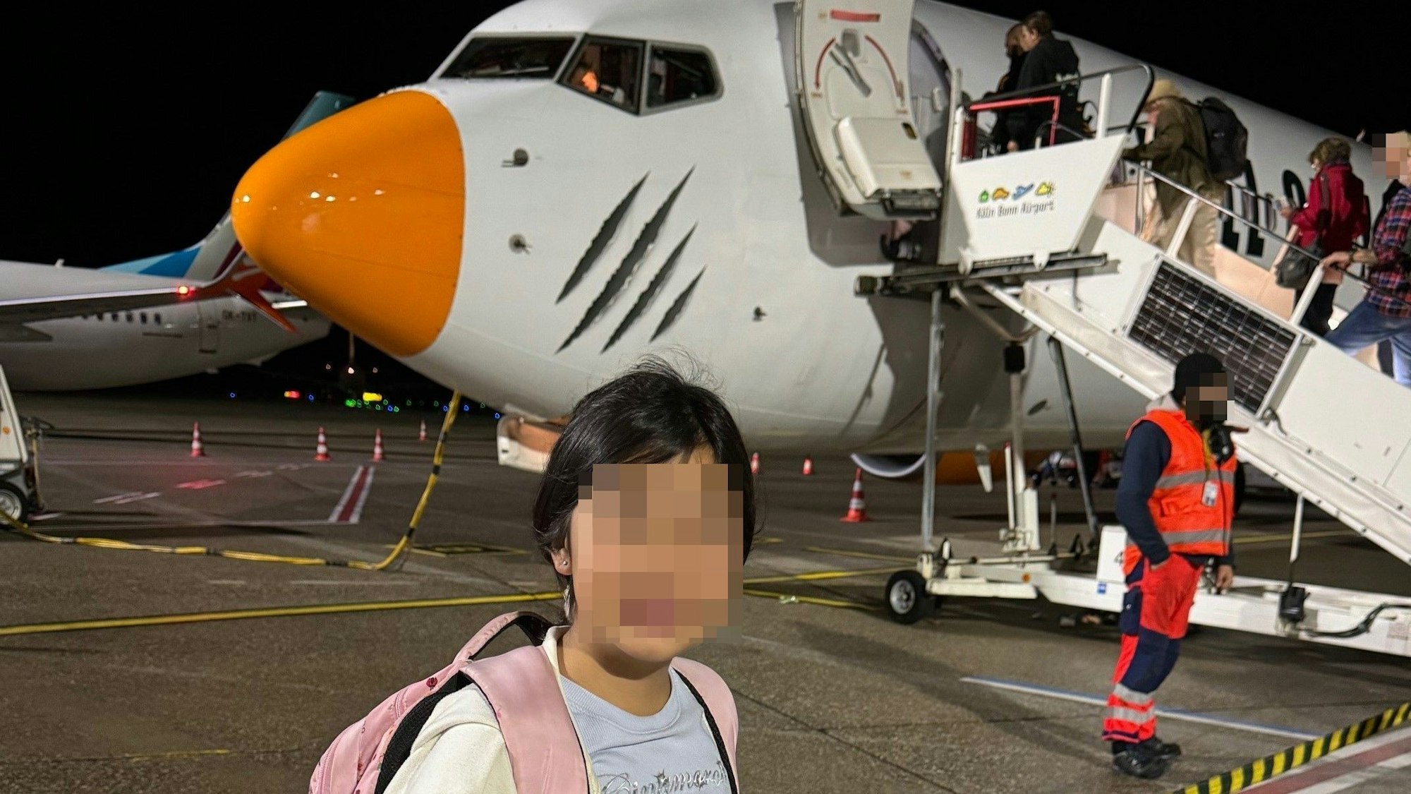 Tochter Mira am Abreisetag in den Kreta-Urlaub vor dem Flugzeug am Flughafen in Köln.