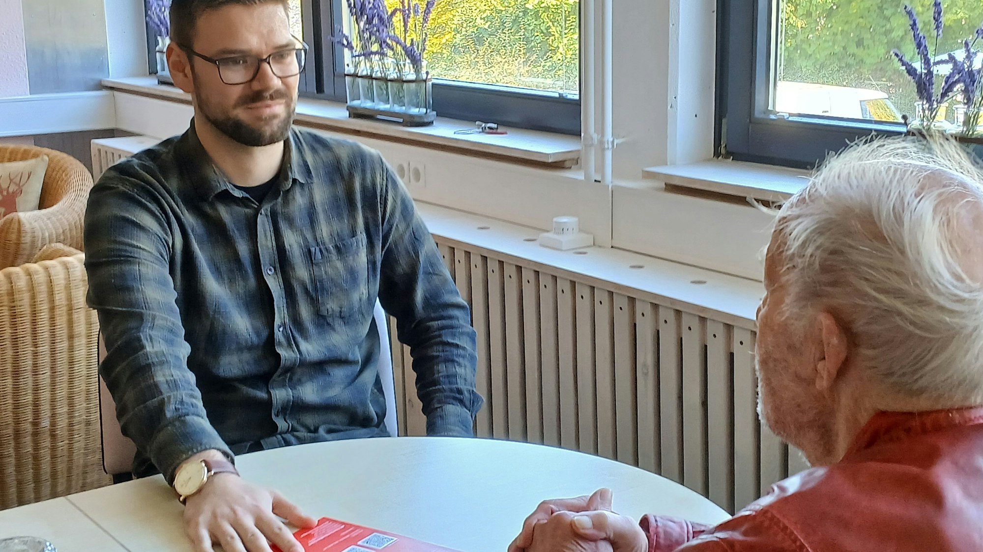 Zwei Männer sitzen sich an einem Tisch gegenüber