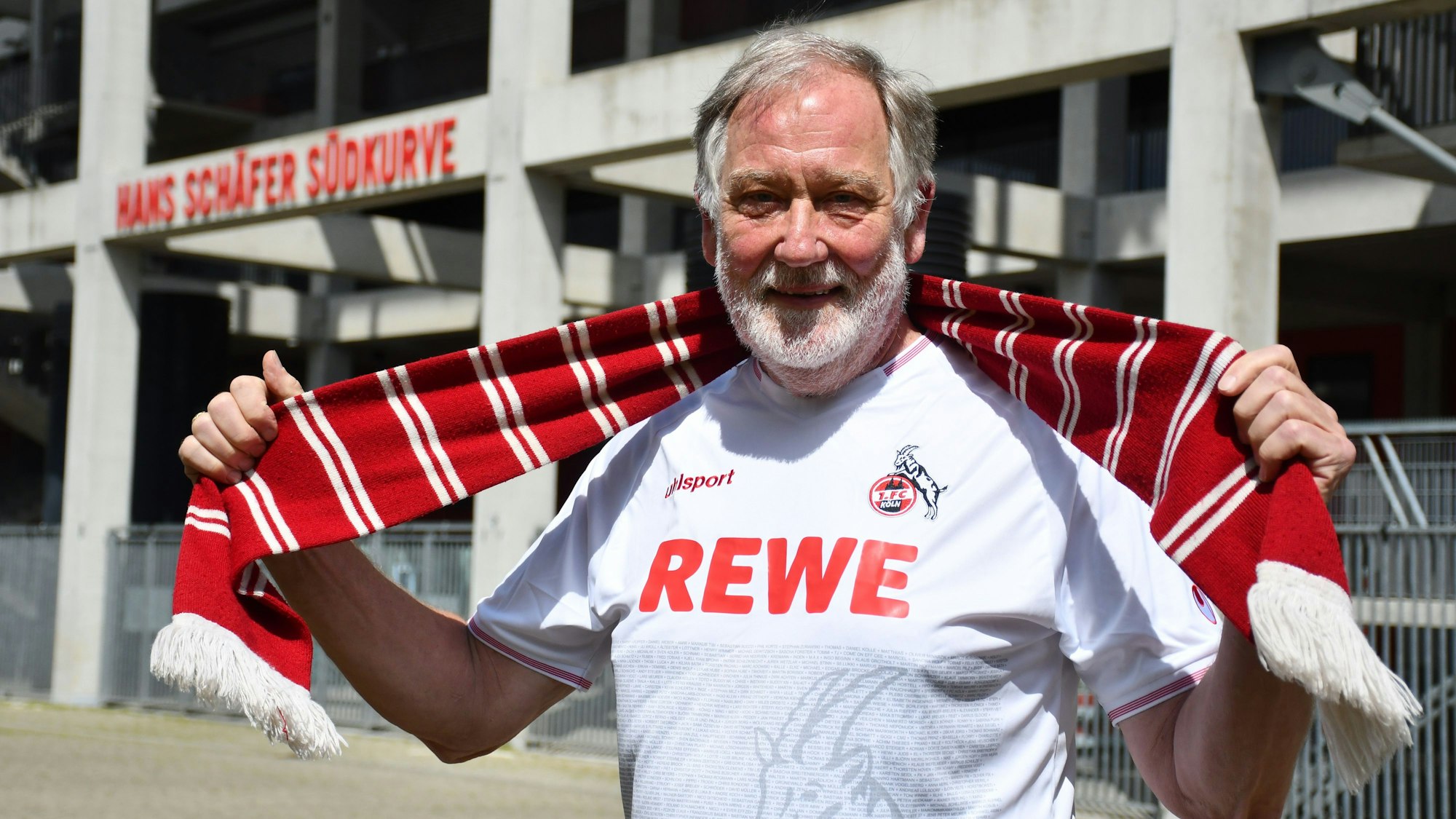 Das Foto zeigt einen Mann im FC-Trikot, der vor der Südtribüne einen Schal hochhält.