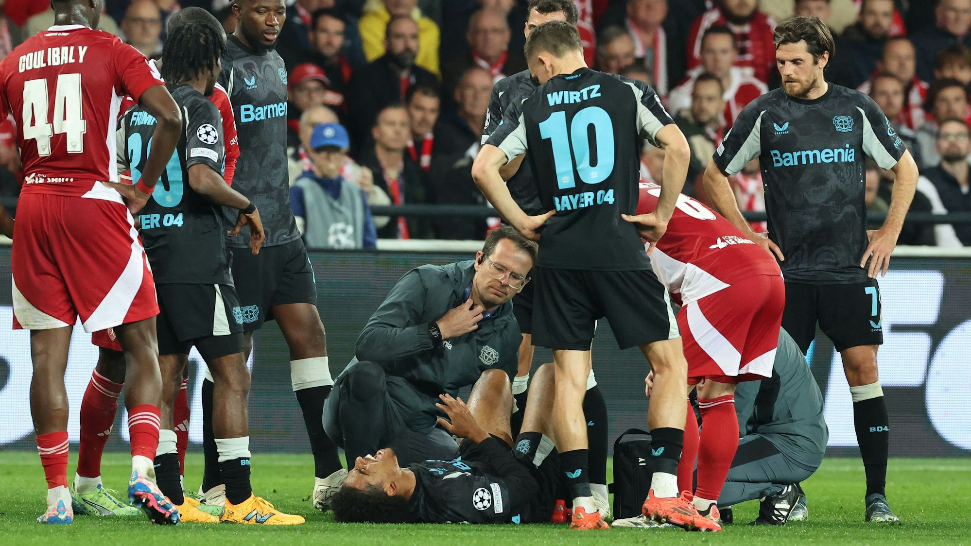 Bayer Leverkusen's Moroccan forward #21 Amine Adli (C) receives medical attention as he lies injured on the ground during the UEFA Champions League 1st round day 3 football match between Brest (FRA) and Bayer Leverkusen (GER) at the Stade de Roudourou in Guingamp, northern France, on October 23, 2024. (Photo by FRED TANNEAU / AFP)