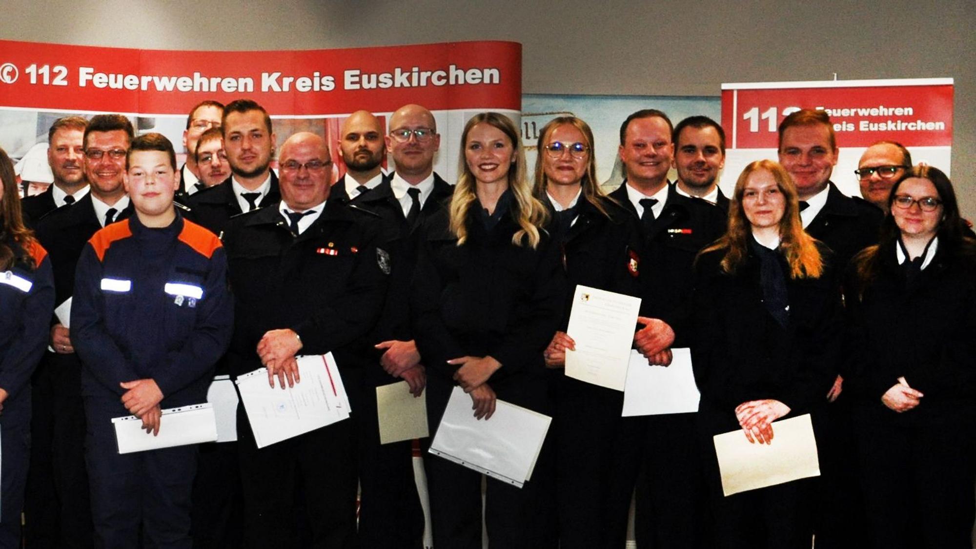 Einsatzkräfte des Löschzugs Kall posieren mit Urkunden für den Fotografen.