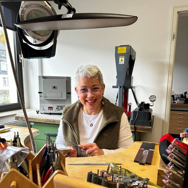 Angela Klussmann sitzt in ihrer Werkstatt, in der sie Schmuck herstellt.