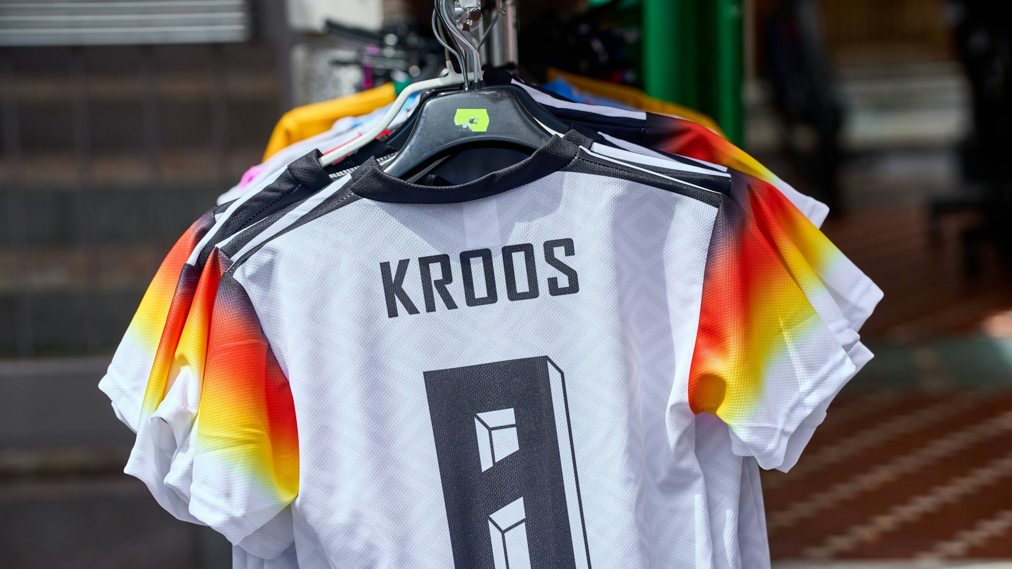 Auf einem Straßenmarkt werden gefälschte Deutschland Trikots günstig angeboten.