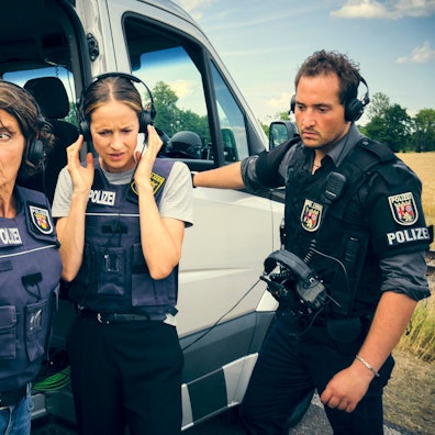 Lena Odenthal, gespielt von Ulrike Folkerts, und Johanna Stern, gespielt von Lisa Bitter, stehen in Uniform hinter einem Transporter.