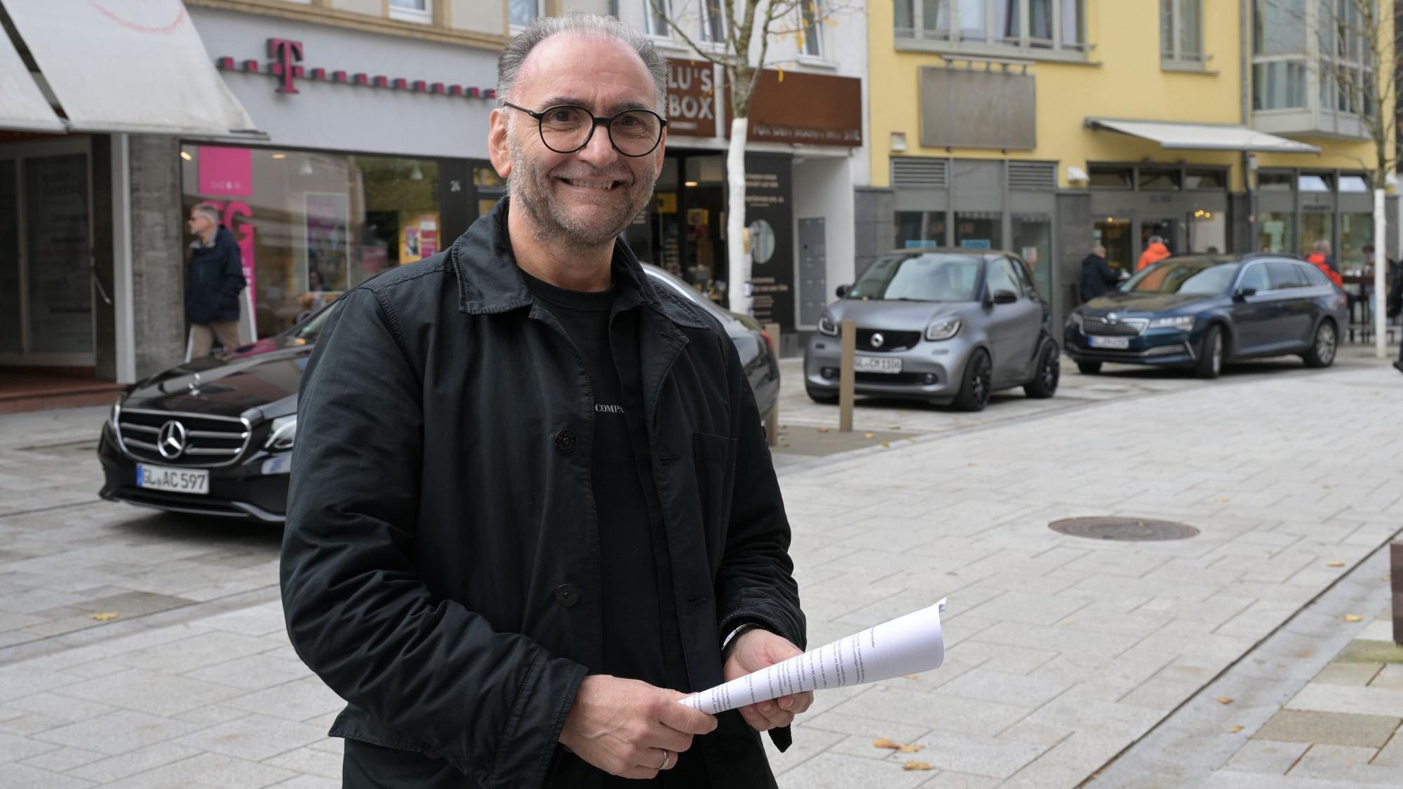 Der Geschäftsmann hält die Unterschriftenliste in der Hand.
