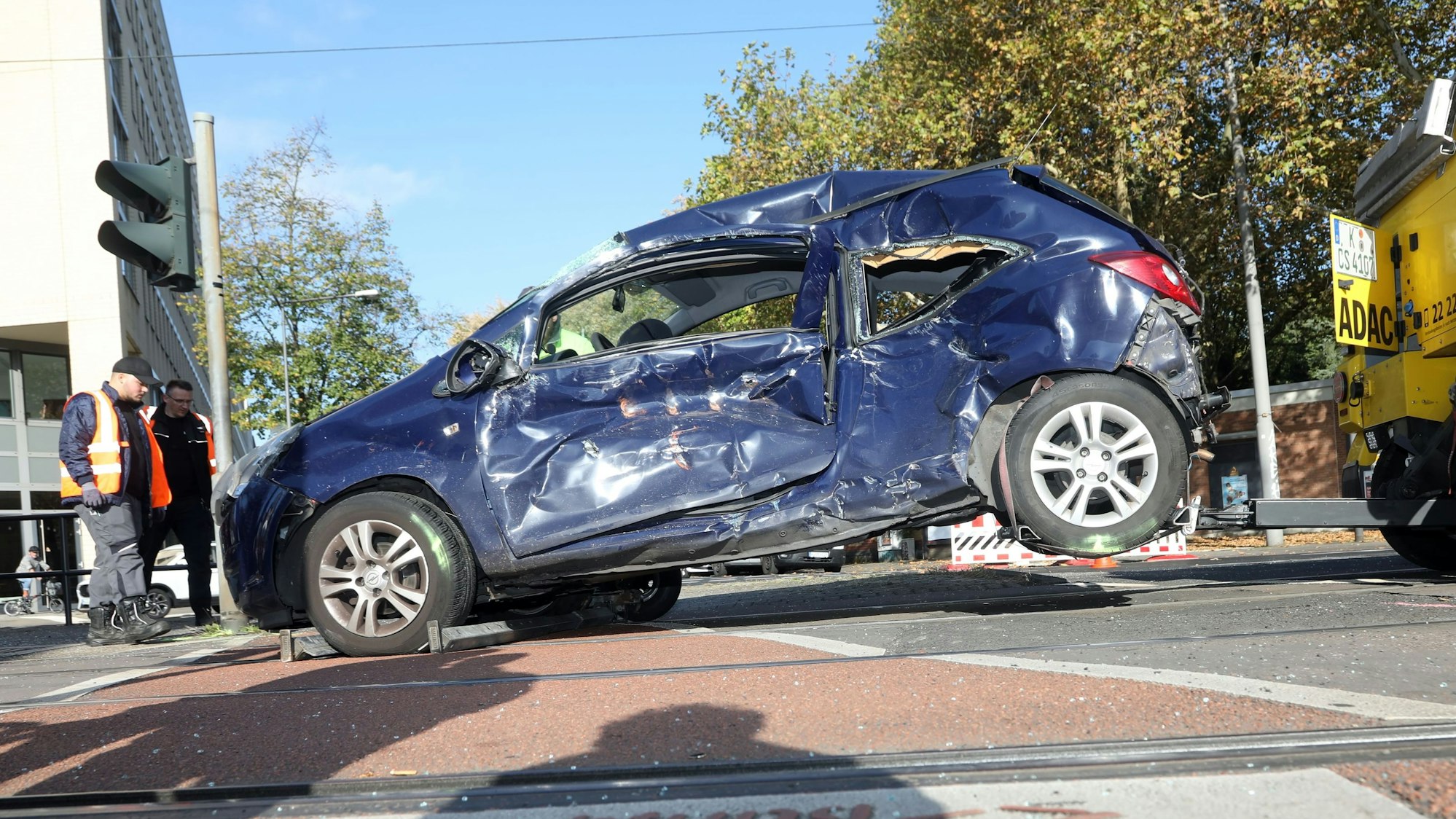 Ein zerbeultes, blaues Auto wird von einem ADAC-Fahrzeug abgeschleppt.