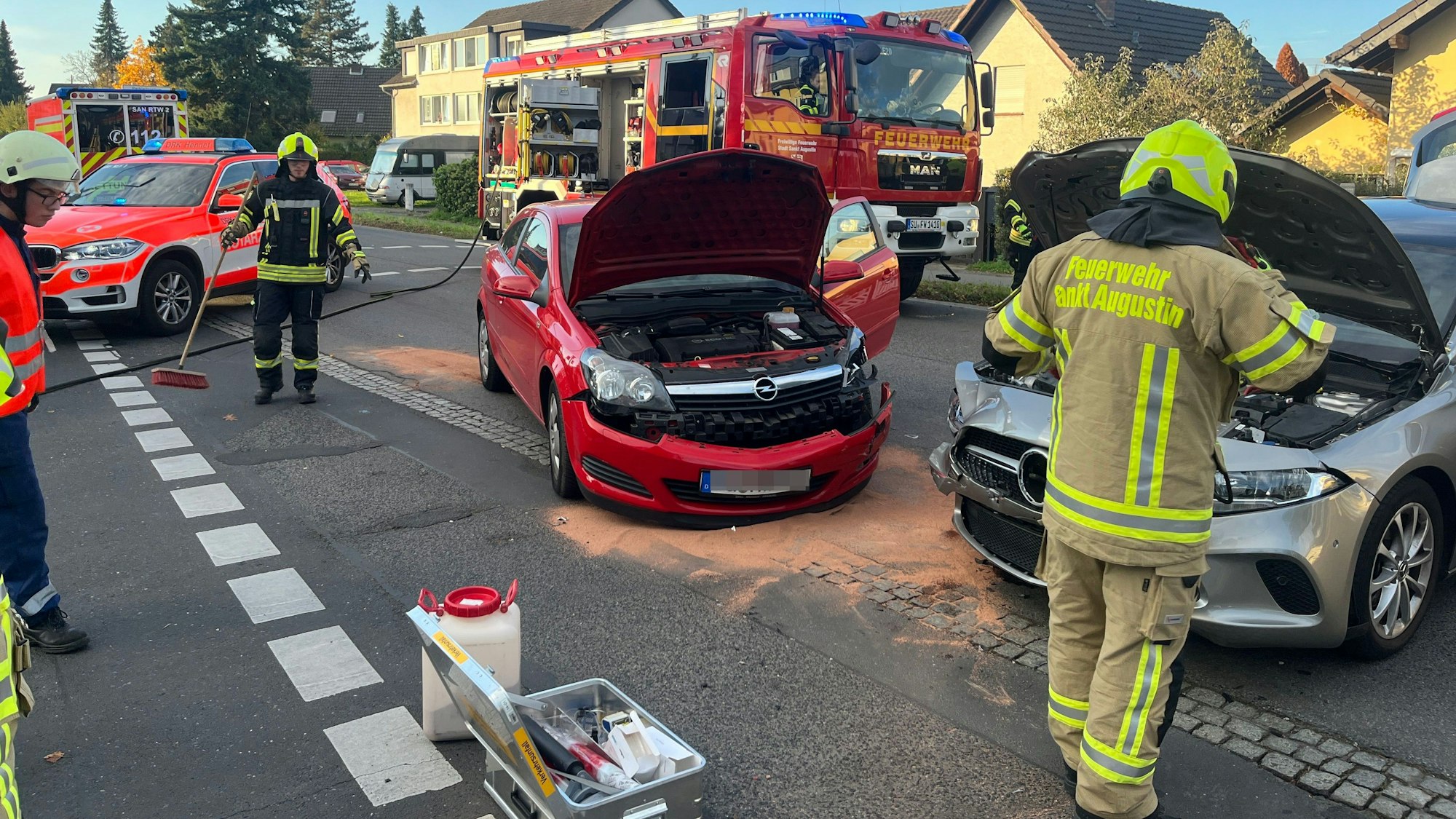 Feuerwehrleute arbeiten an zwei Autos, die zusammengestoßen sind.