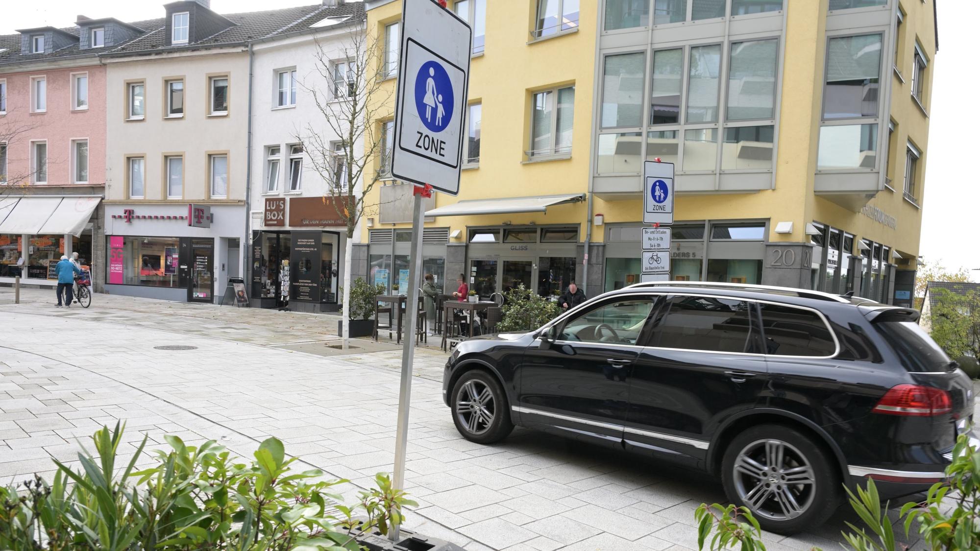 Ein Auto fährt an dem Verkehrsschild Fußgängerzone vorbei.