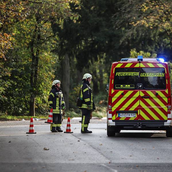 Zwei Feuerwehrleute stehen an einem Einsatzwagen.