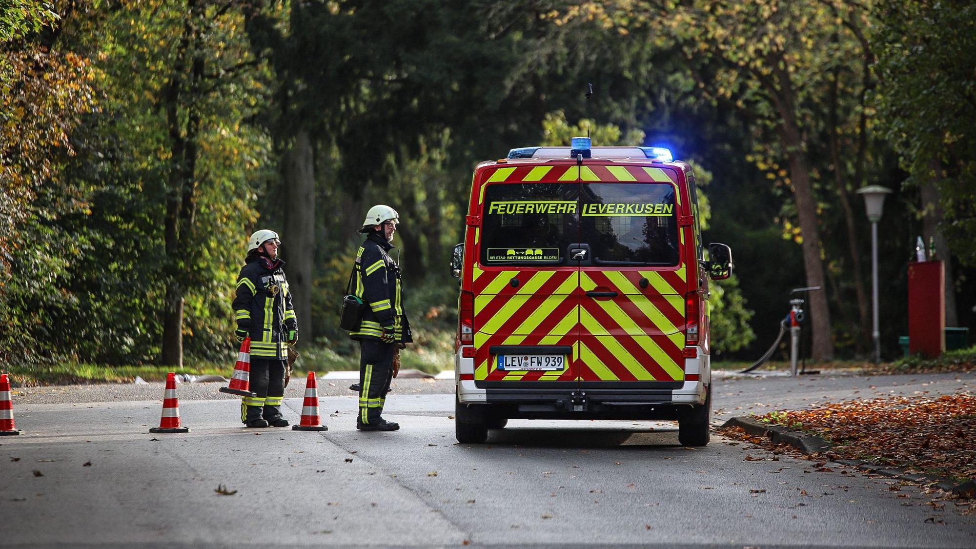 Zwei Feuerwehrleute stehen an einem Einsatzwagen.