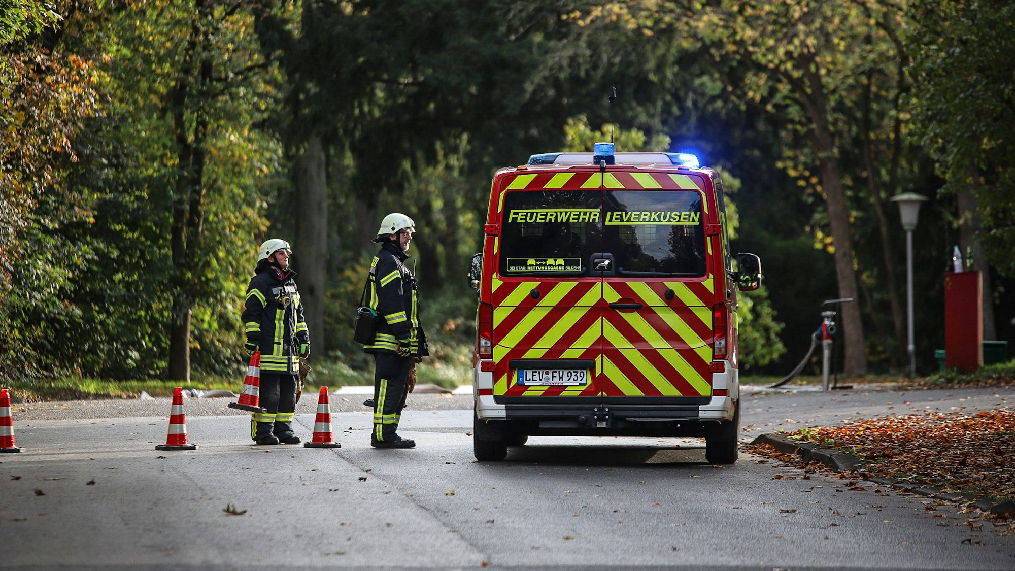Zwei Feuerwehrleute stehen an einem Einsatzwagen.