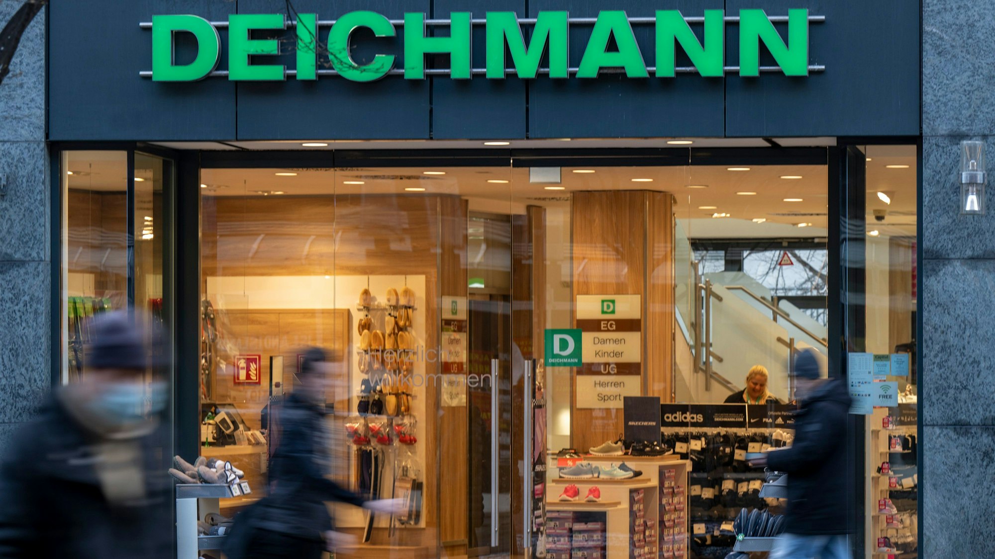 Das Logo der Handelskette Deichmann ist an der Fassade über dem Eingang zu einem Deichmann-Geschäft angebracht.