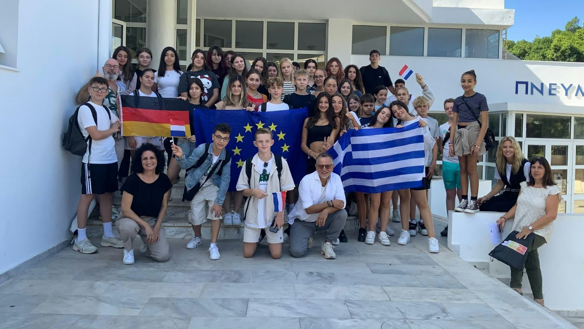 Das Bild zeigt Schülerinnen und Schüler, die diverse Flaggen hochhalten.