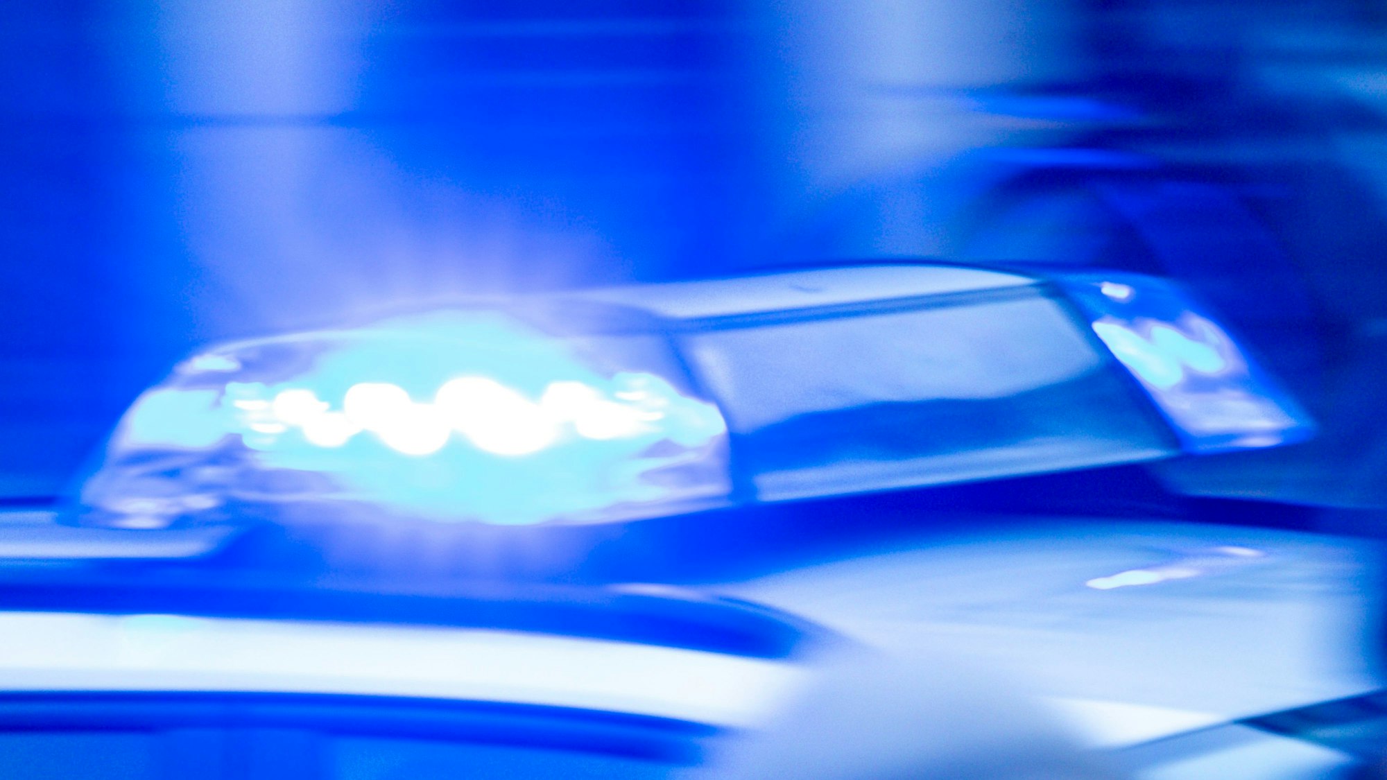 Ein Streifenwagen der Polizei ist mit Blaulicht im Einsatz.