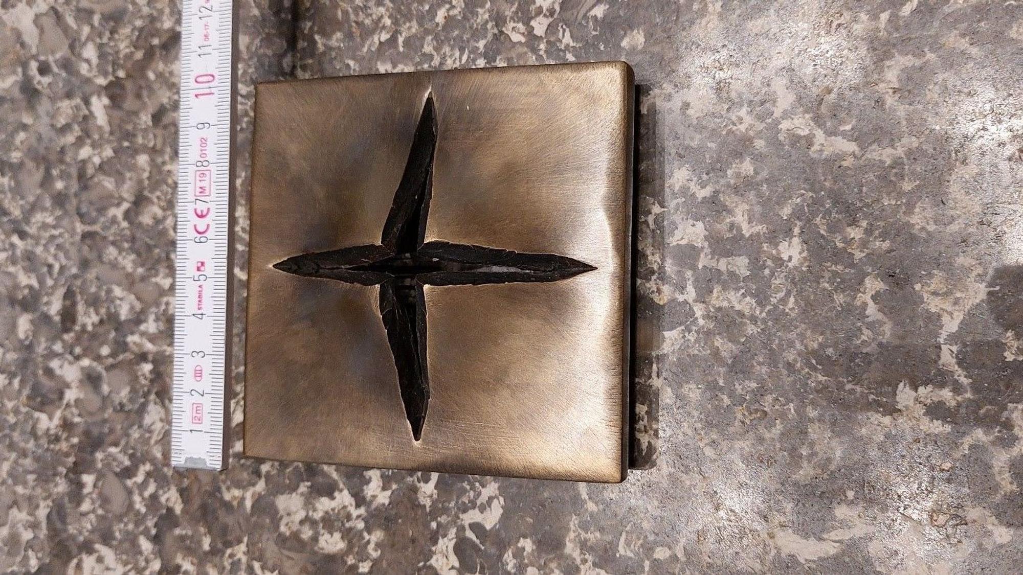 Das gestohlene, moderne Kreuz aus Bronze: Eine Metallplatte, die in Form eines Kreuzes aufreißt.