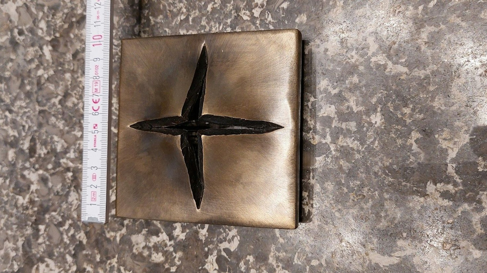 Das gestohlene, moderne Kreuz aus Bronze: Eine Metallplatte, die in Form eines Kreuzes aufreißt.