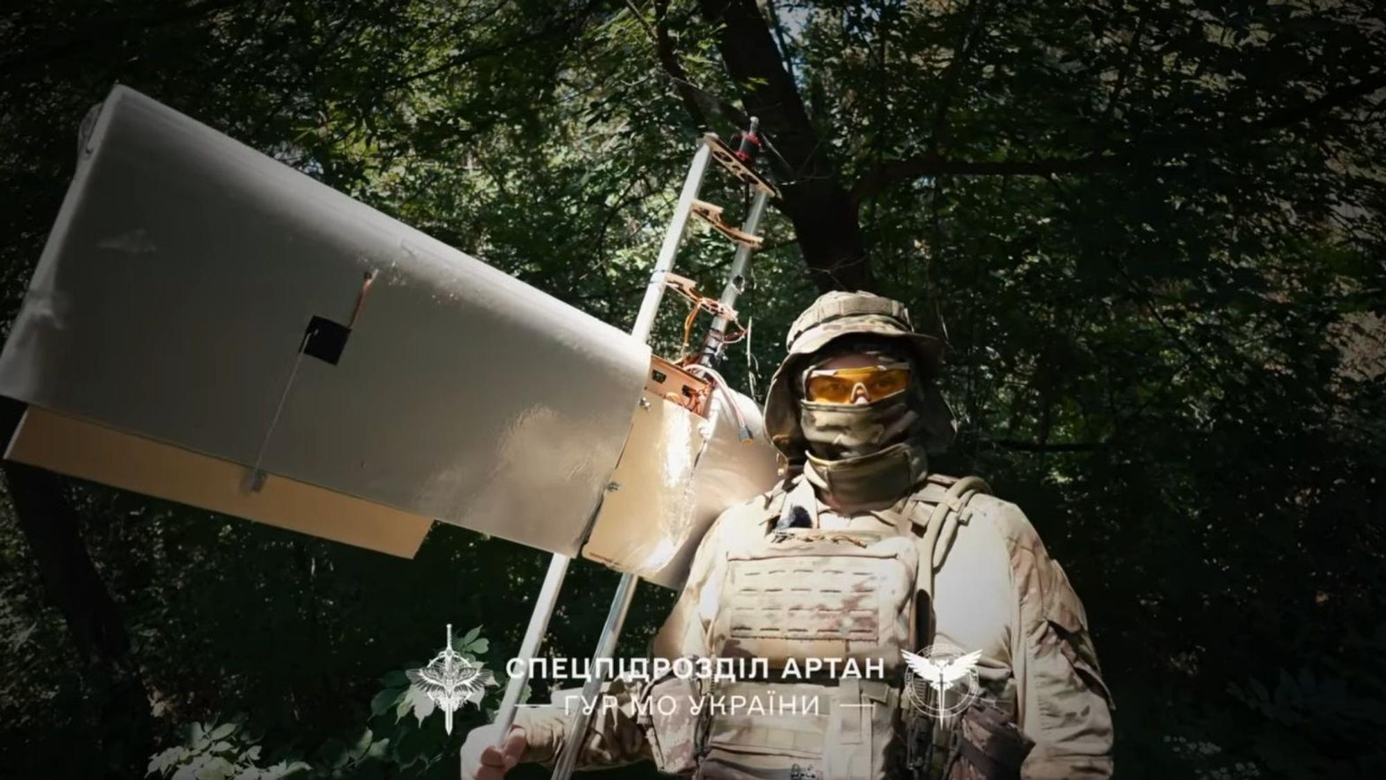 Ein ukrainischer Soldat posiert mit einer den Angaben nach russischen Drohne, die er abgeschossen haben soll.