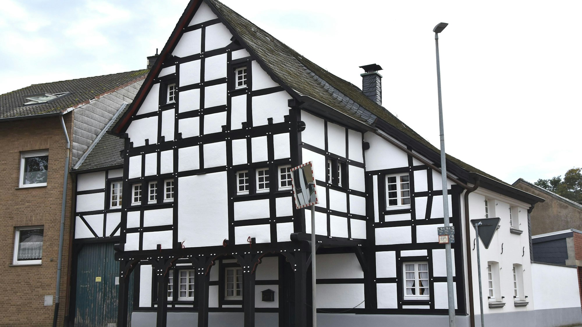 Zu sehen ist ein Fachwerkhaus an einer Straße.