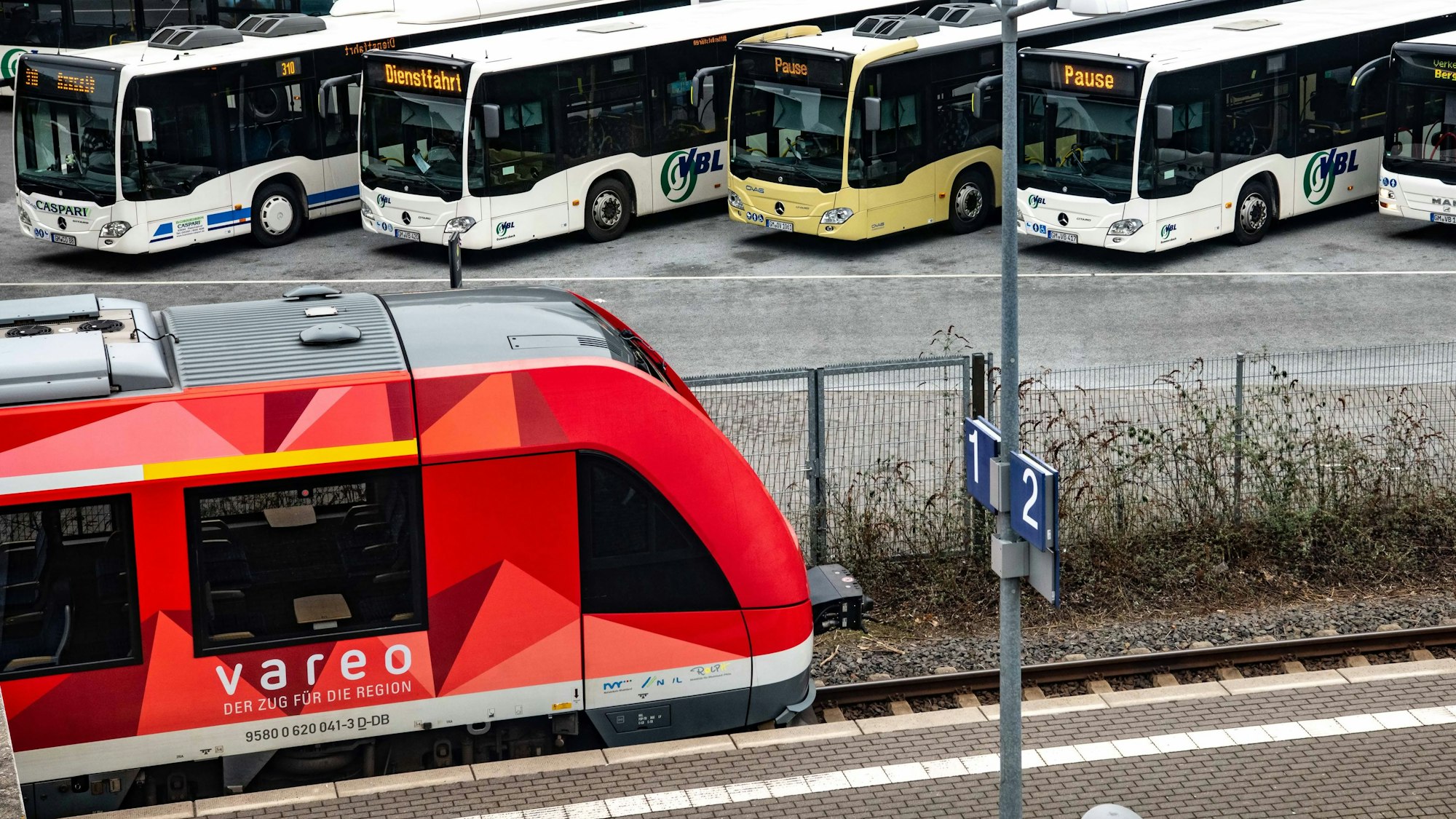 Zu sehen ist die Regionalbahn 25, im Hintergrund stehen Busse der Ovag.