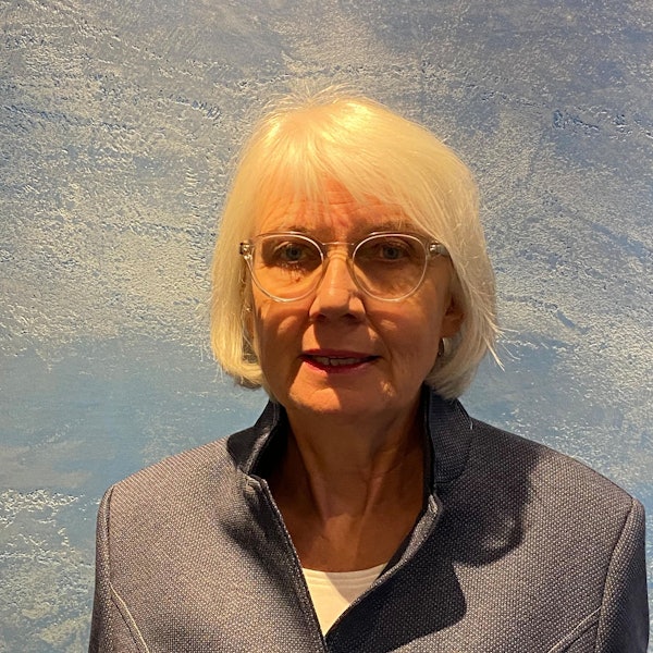 Die Preisträgerin, sie hat weiße Haare, die ihr bis zum Kinn reichen und trägt eine transparente Brille.