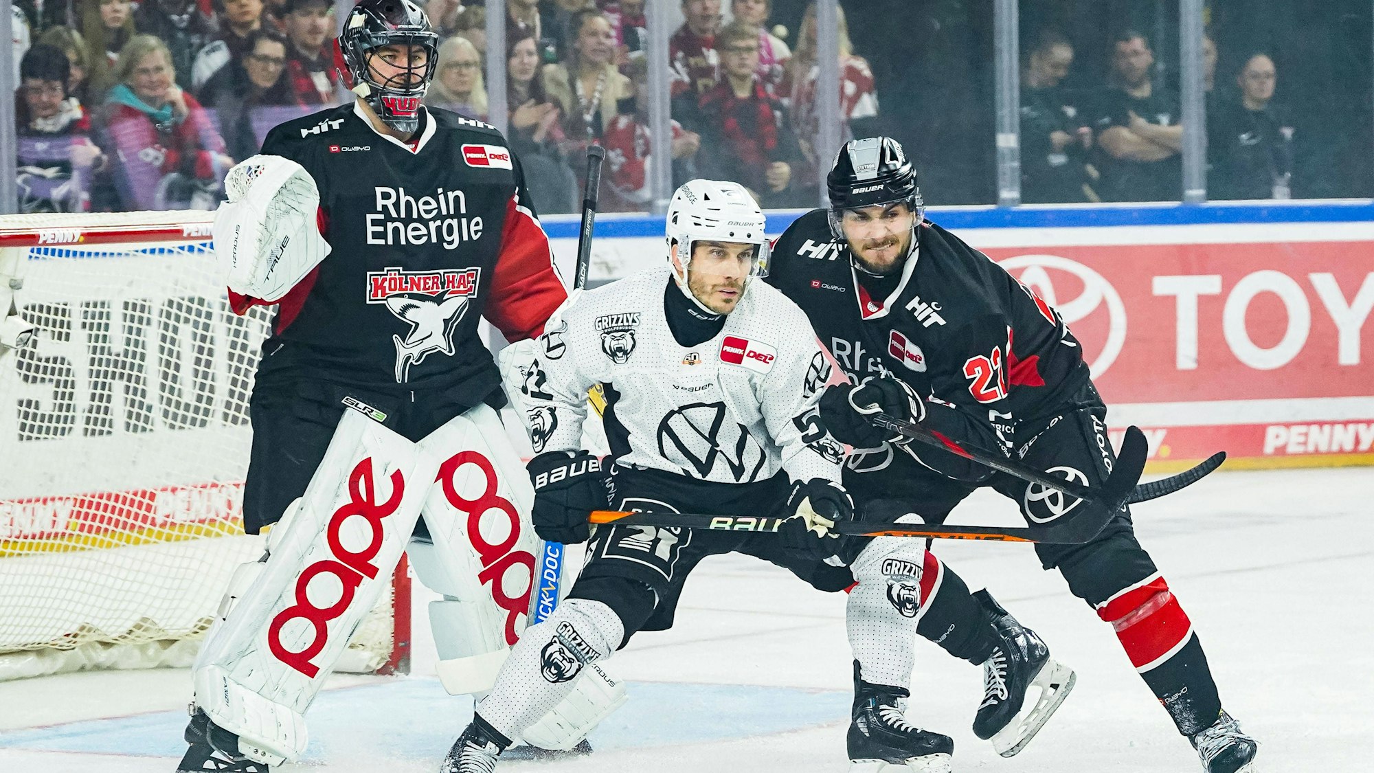 Haie-Goalie Julius Hudacek (l.) mit Wolfsburgs Andy Miele und Kölns Maximilian Glötzl