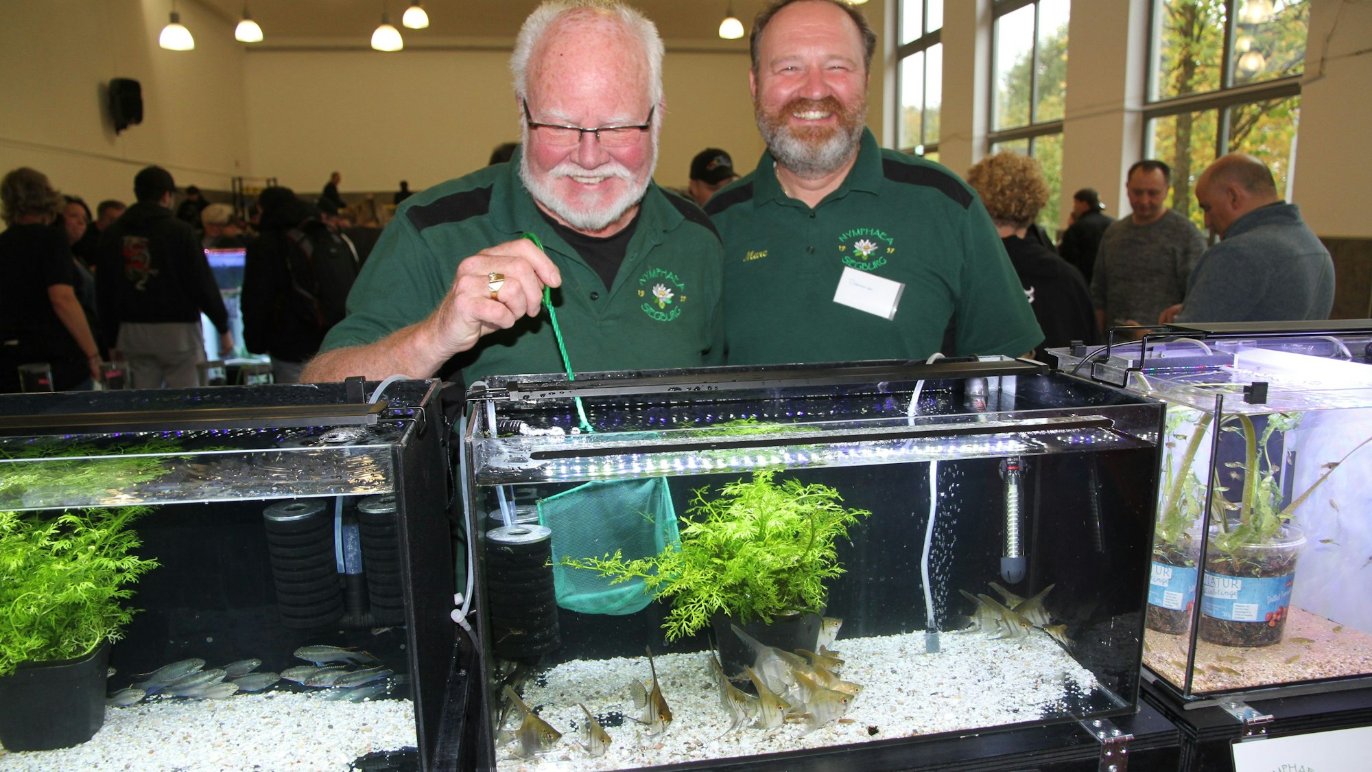 Zwei Männer hinter einem Aquarium mit Zierfischen