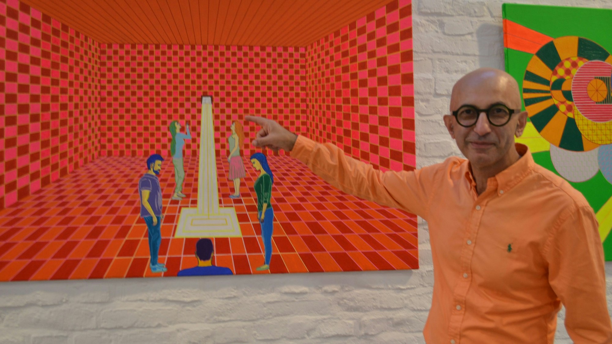 Ein Mann mit Brille steht vor einem roten, gerasterten Bild.