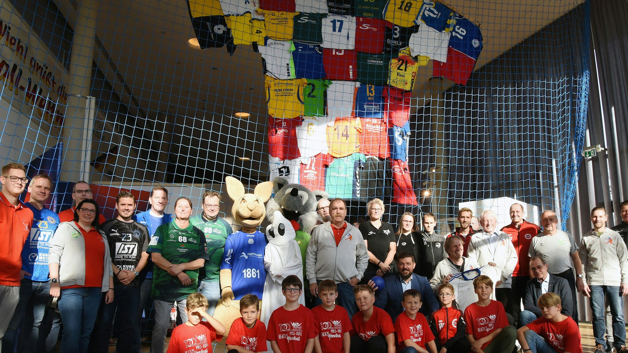 In einem Netz ist das große Trikot befestigt. Davor haben sich die Besucher der Ausstellung platziert.