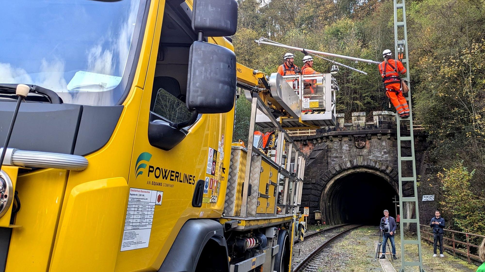Arbeiter bei der Montage eines Flachmasts mit angelenktem Ausleger am Eingang zum Wilsecker Tunnel bei Kyllburg.