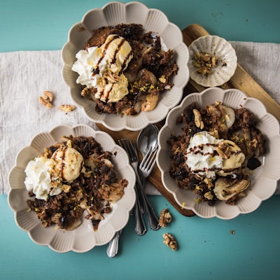 Drei Schüsseln mit Birnen-Schokoladen-Crumble stehen auf einem Tisch.