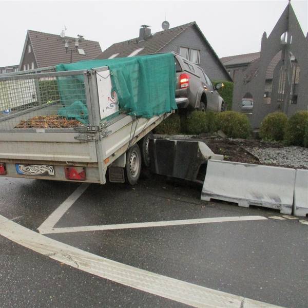 Ein Auto mit Anhänger steht am Montag (28.10.) im Hochbeet des Kreisverkehrs in Odenthal-Blecher.