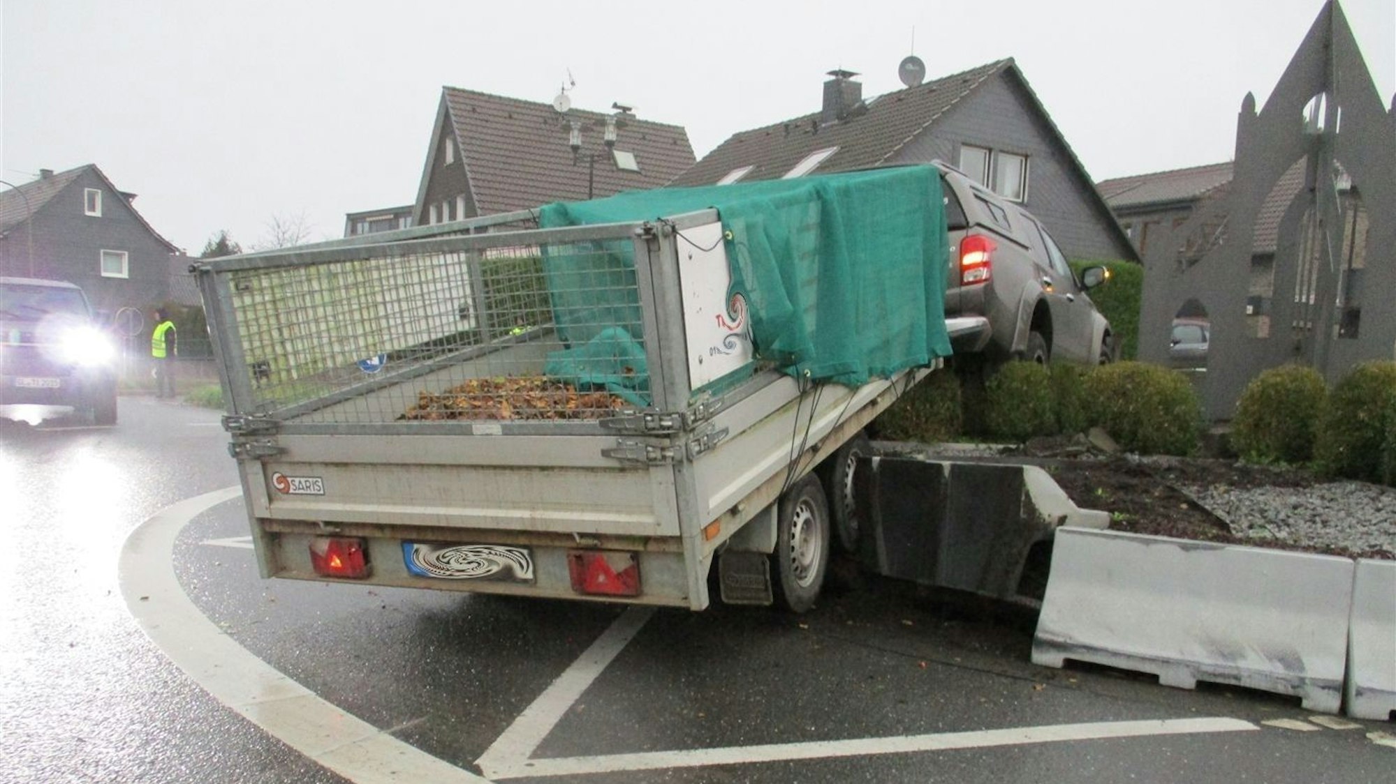 Ein Auto mit Anhänger steht am Montag (28.10.) im Hochbeet des Kreisverkehrs in Odenthal-Blecher.