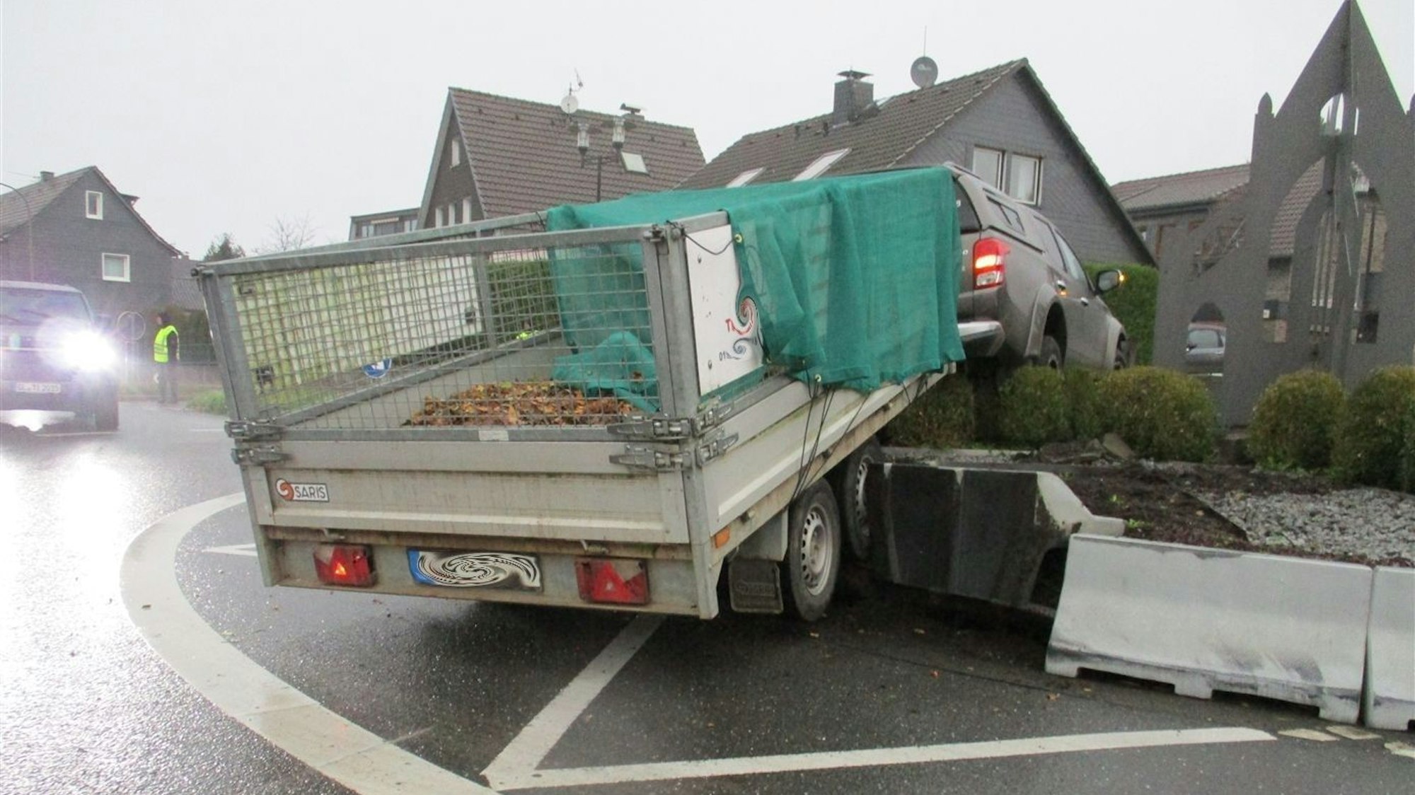 Ein Auto mit Anhänger steht am Montag (28.10.) im Hochbeet des Kreisverkehrs in Odenthal-Blecher.