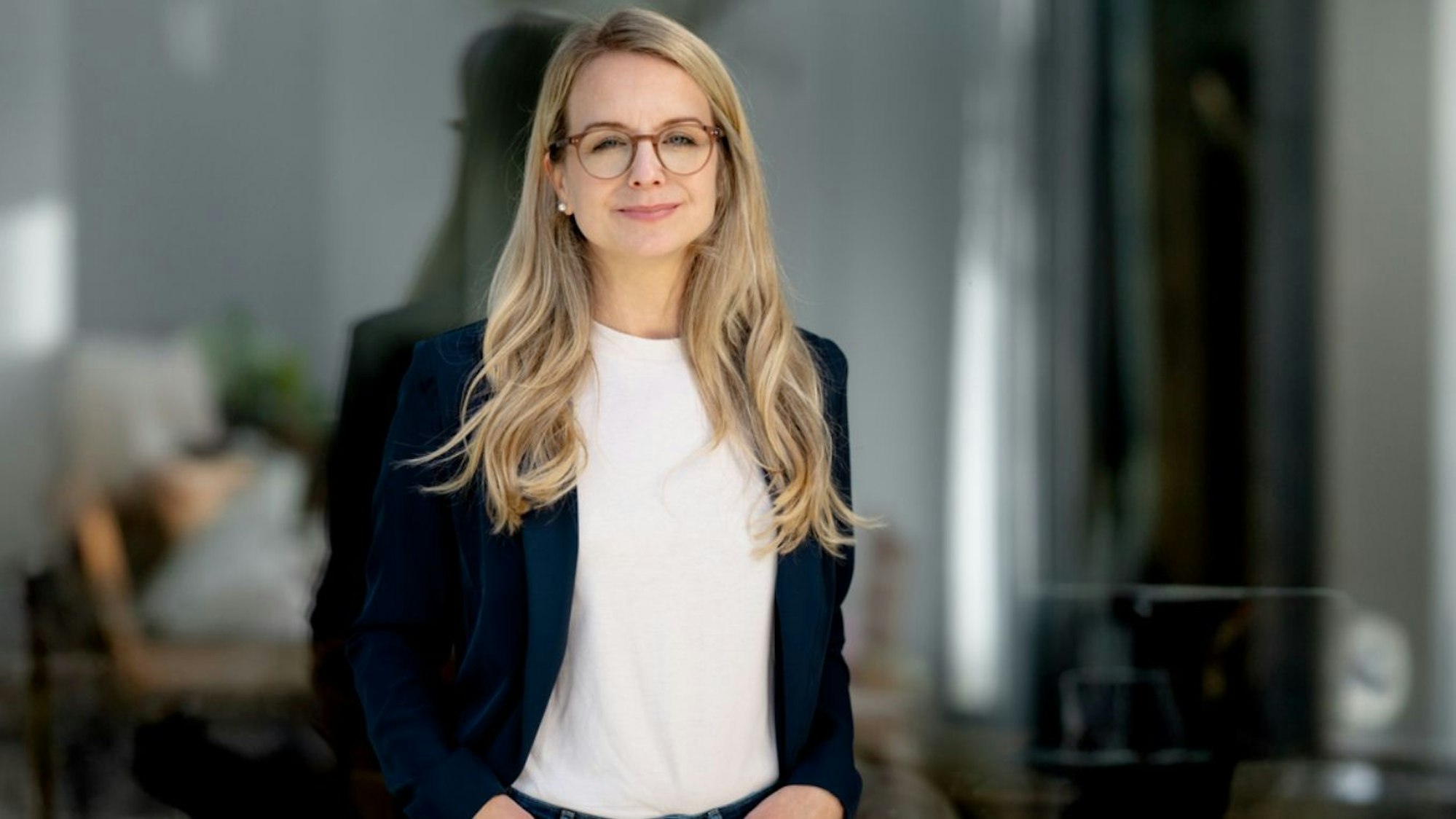 Bürgermeisterkandidatin Laura Lundberg steht vor eine Glasscheibe.