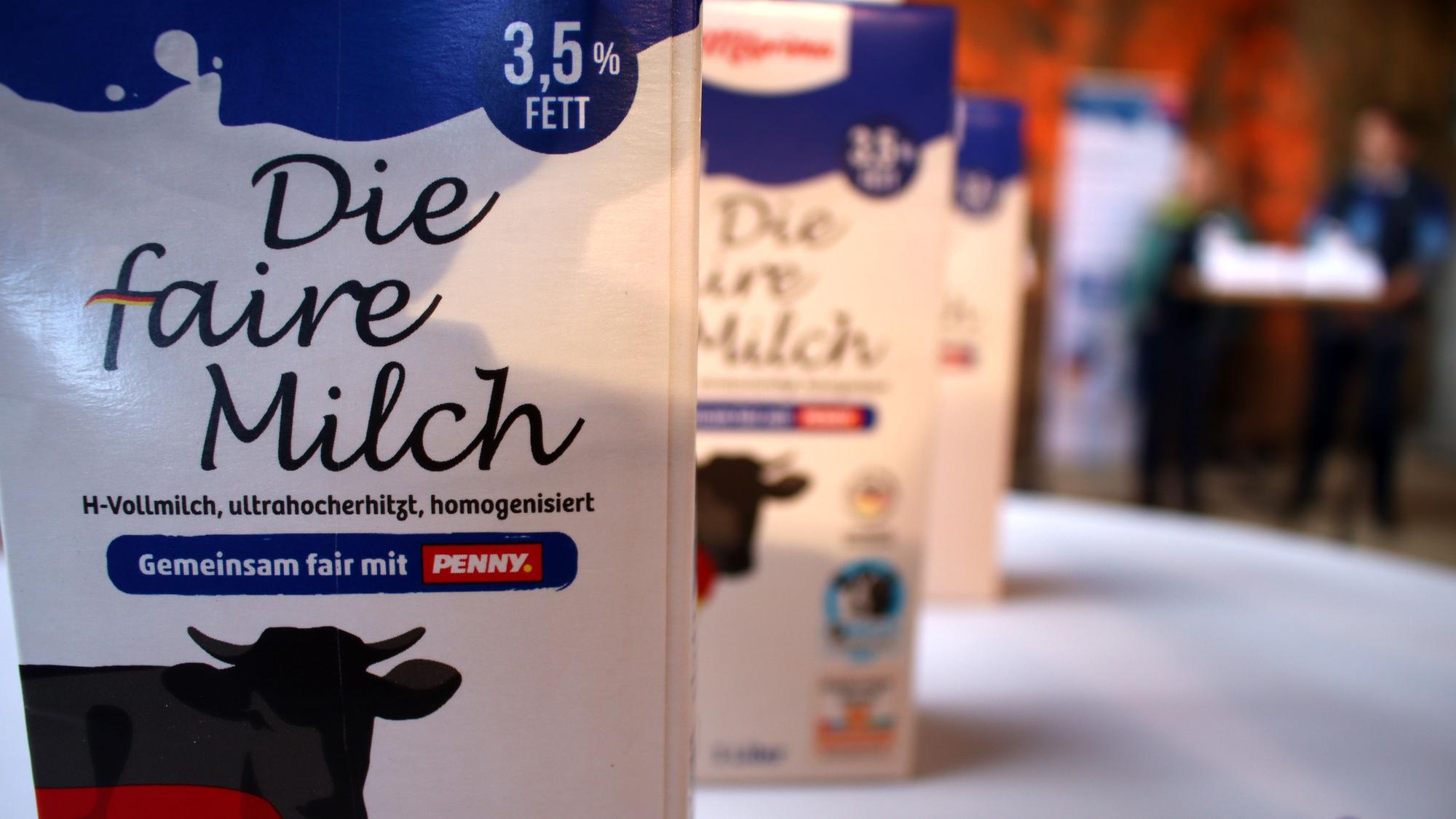 Milchpackungen stehen hintereinander auf einem Tisch.