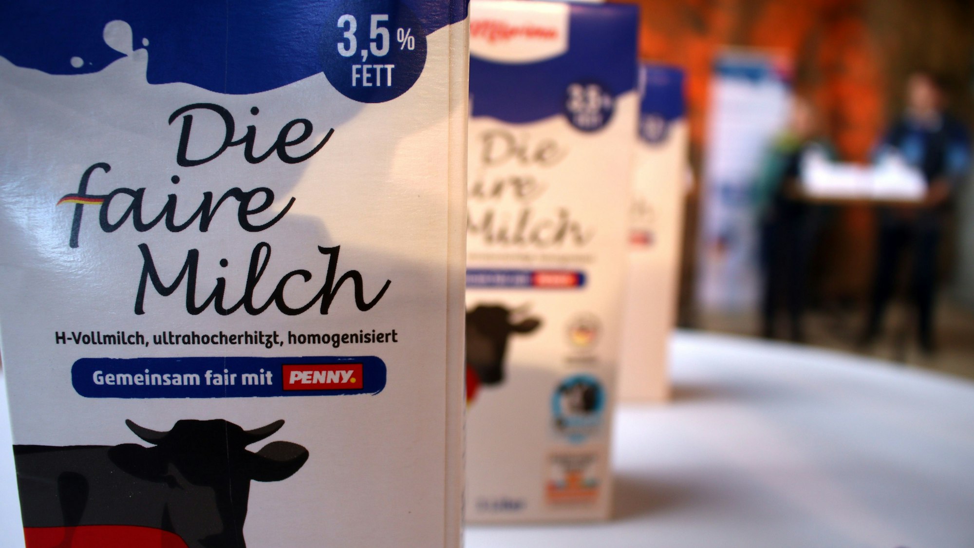 Milchpackungen stehen hintereinander auf einem Tisch.