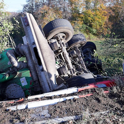 Ein Gülleanhänger liegt umgestürzt hinter einer durch den Unfall beschädigten Leitplanke.