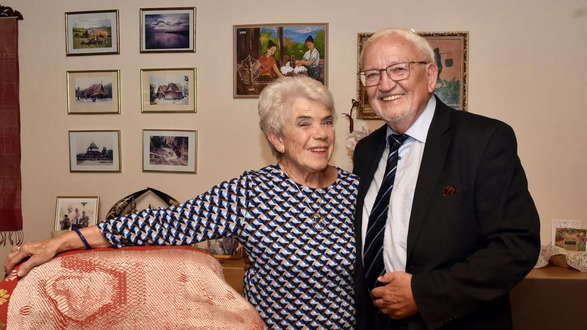 Das Ehepaar Ludwig und Anneliese Neuber vor einer Wand mit Bildern.