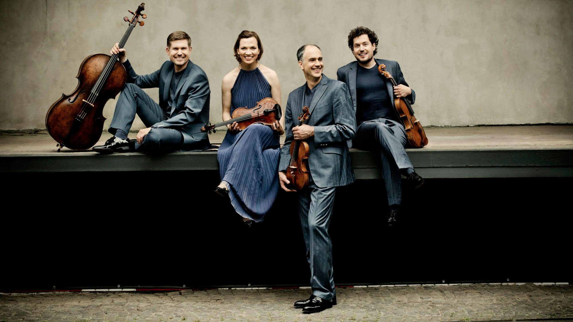 Vier Musiker sitzen auf einer Rampe.