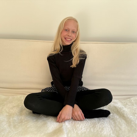 Die zwölfjährige Gymnasiastin Maja Mainka aus Köln-Weiß sitzt auf ihrem Bett.