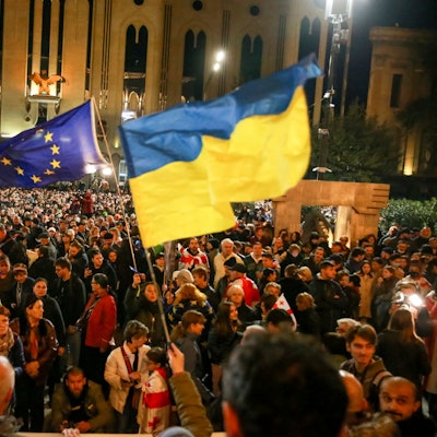 Demonstranten schwenken EU- und ukrainische Nationalflaggen, als sie sich während eines Protestes der Opposition gegen die Ergebnisse der Parlamentswahlen in Georgien versammeln.