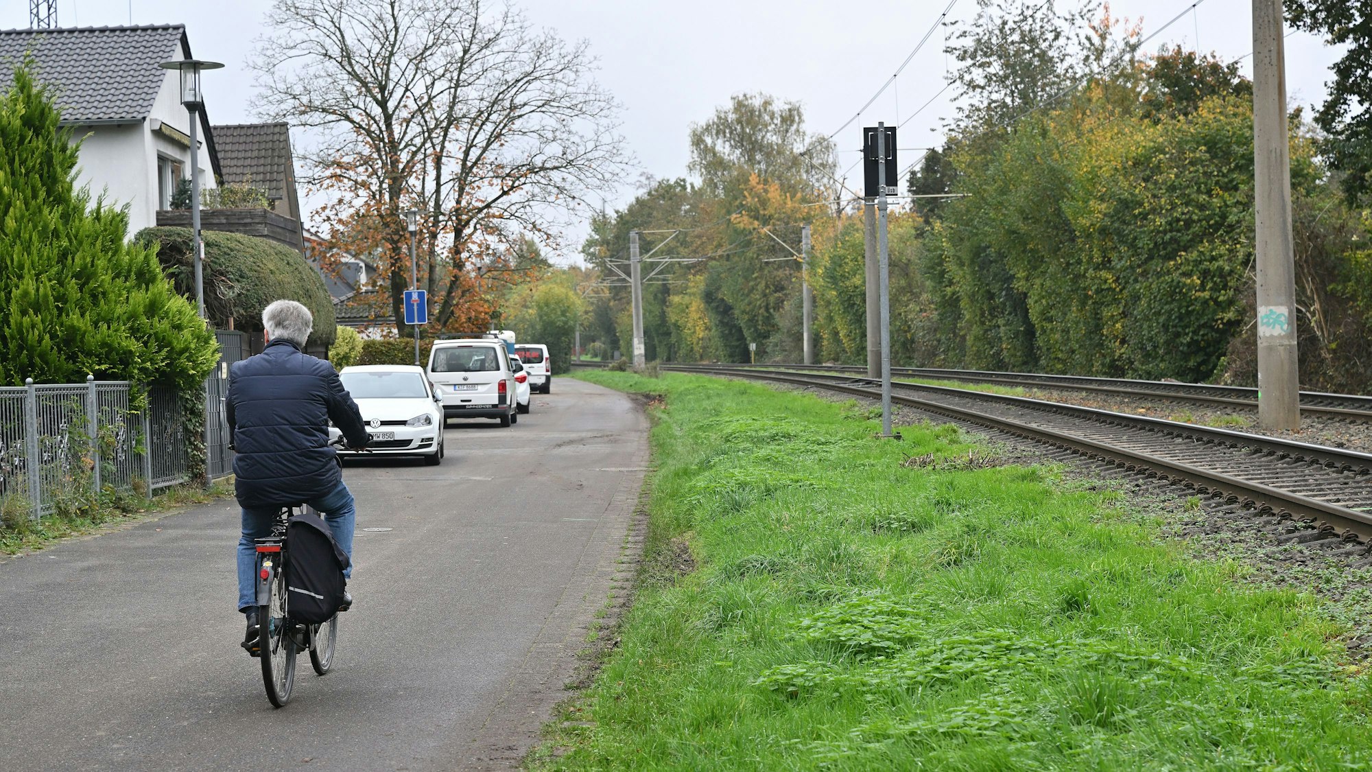 Auf der schmalen Wohnstraße fährt ein Radfahrer.