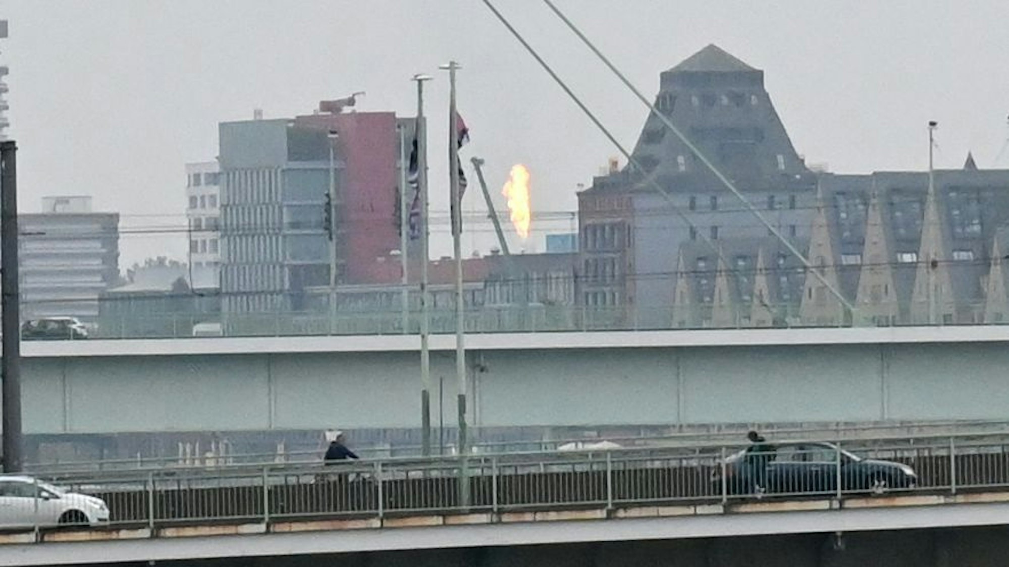 Von der Hohenzollernbrücke aus ist eine riesige Stichflamme über dem Rheinauhafen zu sehen.