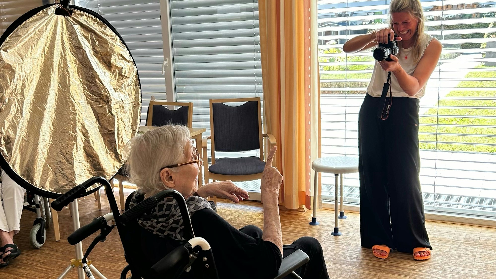 Carina Lange fotografiert eine ältere Heimbewohnerin für die Ausstellung.