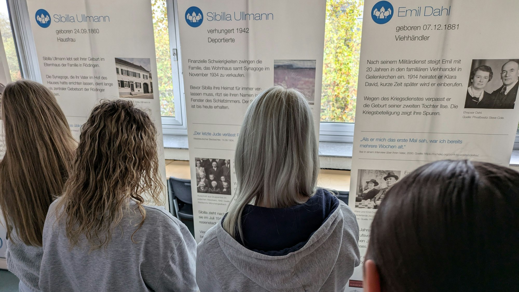 Schülerinnen betrachten Schautafeln in einer Ausstellung.