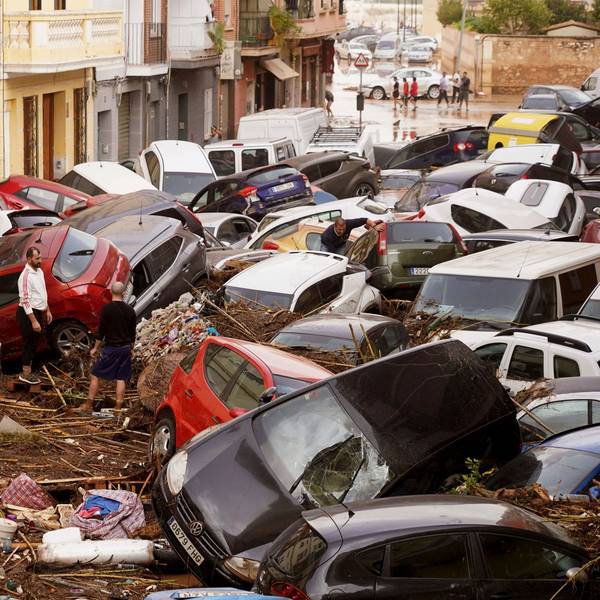 30.10.2024, Spanien, Valencia: Anwohner betrachten durch die Wassermassen aufgestapelte Autos. Foto: Alberto Saiz/AP +++ dpa-Bildfunk +++